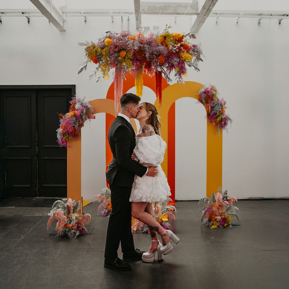 neon-arch-altar-decor-as-bride-and-groom-share-first-kiss