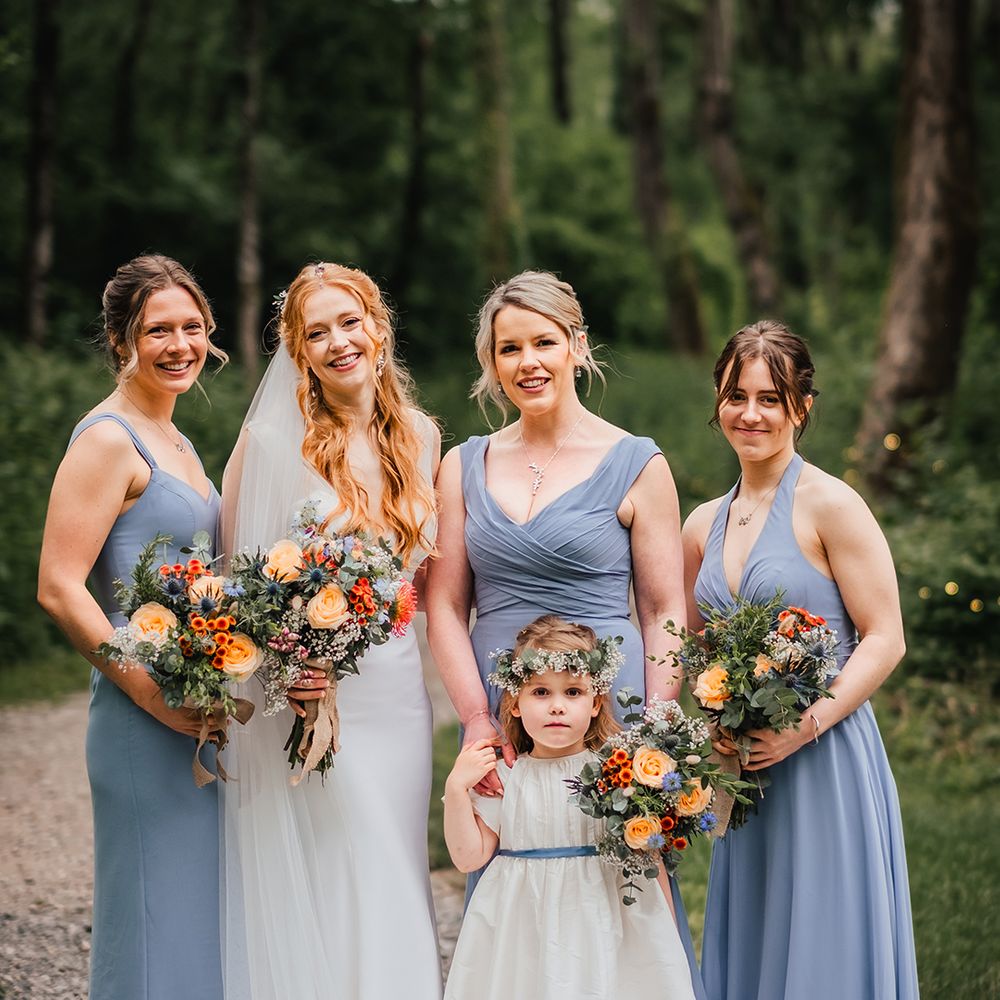 blue-bridesmaid-dresses-with-colourful-dresses-and-flower-girl-in-white-smock-dress