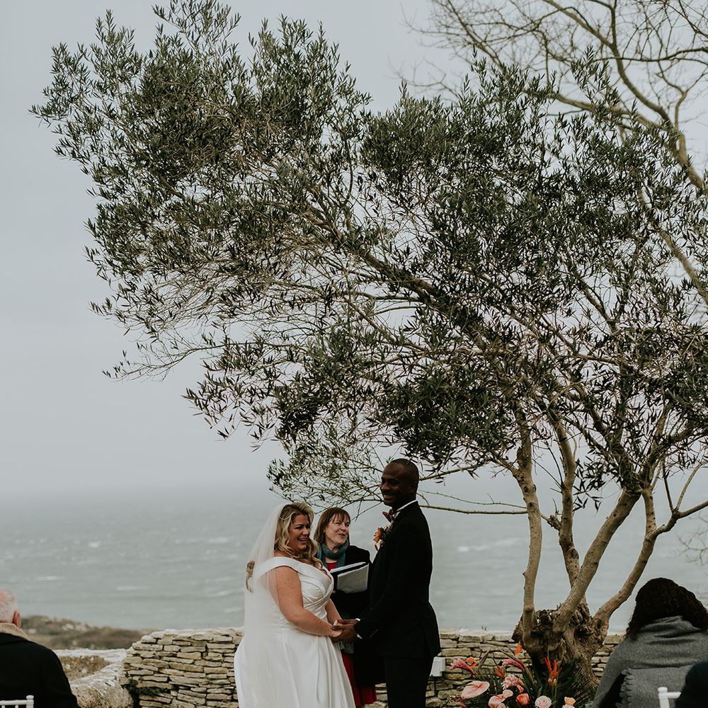 bride-and-groom-say-their-wedding-vows-under-a-tree-at-outdoor-ceremony