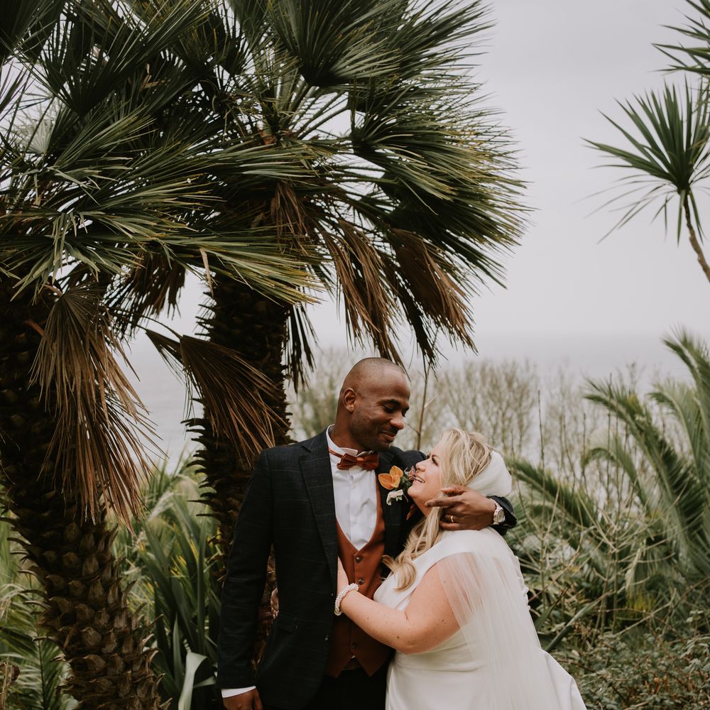 groom-in-three-piece-wedding-suit-embraces-bride-in-classic-wedding-dress
