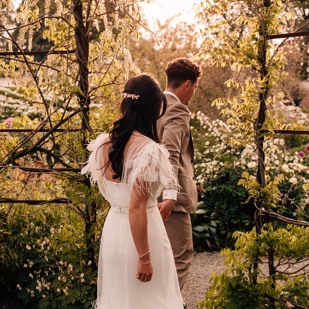 bride-wearing-feather-wedding-dress-with-groom-in-brown-suit