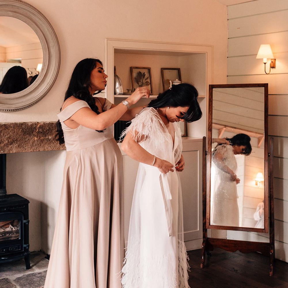 bridesmaid-helps-the-bride-get-ready