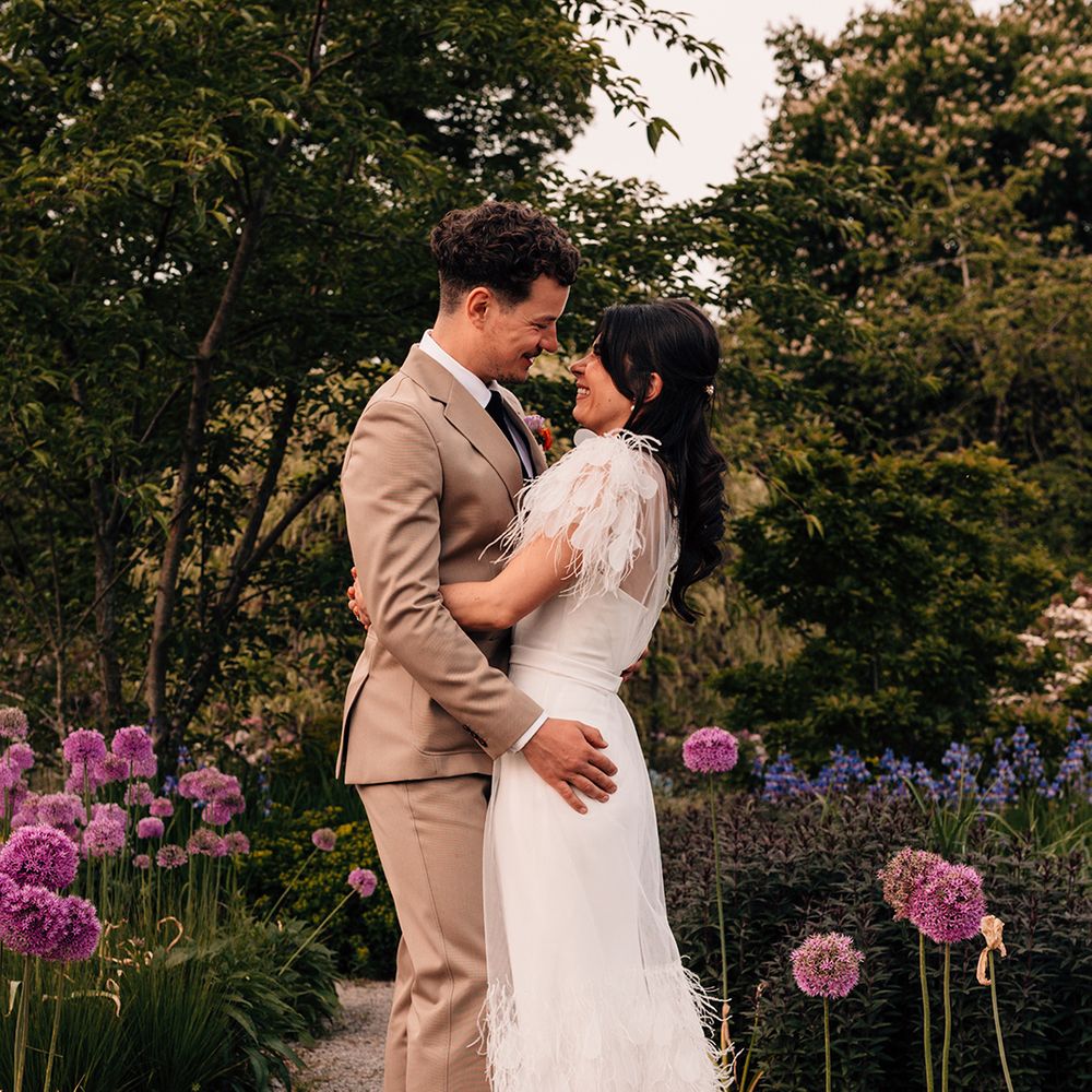 groom-embraces-bride-in-feather-wedding-dresss