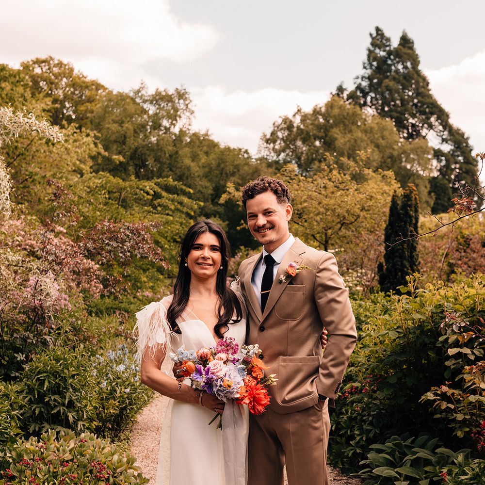 groom-in-brown-wedding-suit-with-bride-in-feather-wedding-dress