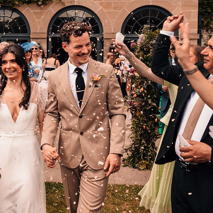 guests-throw-confetti-over-couple-at-outoor-wedding