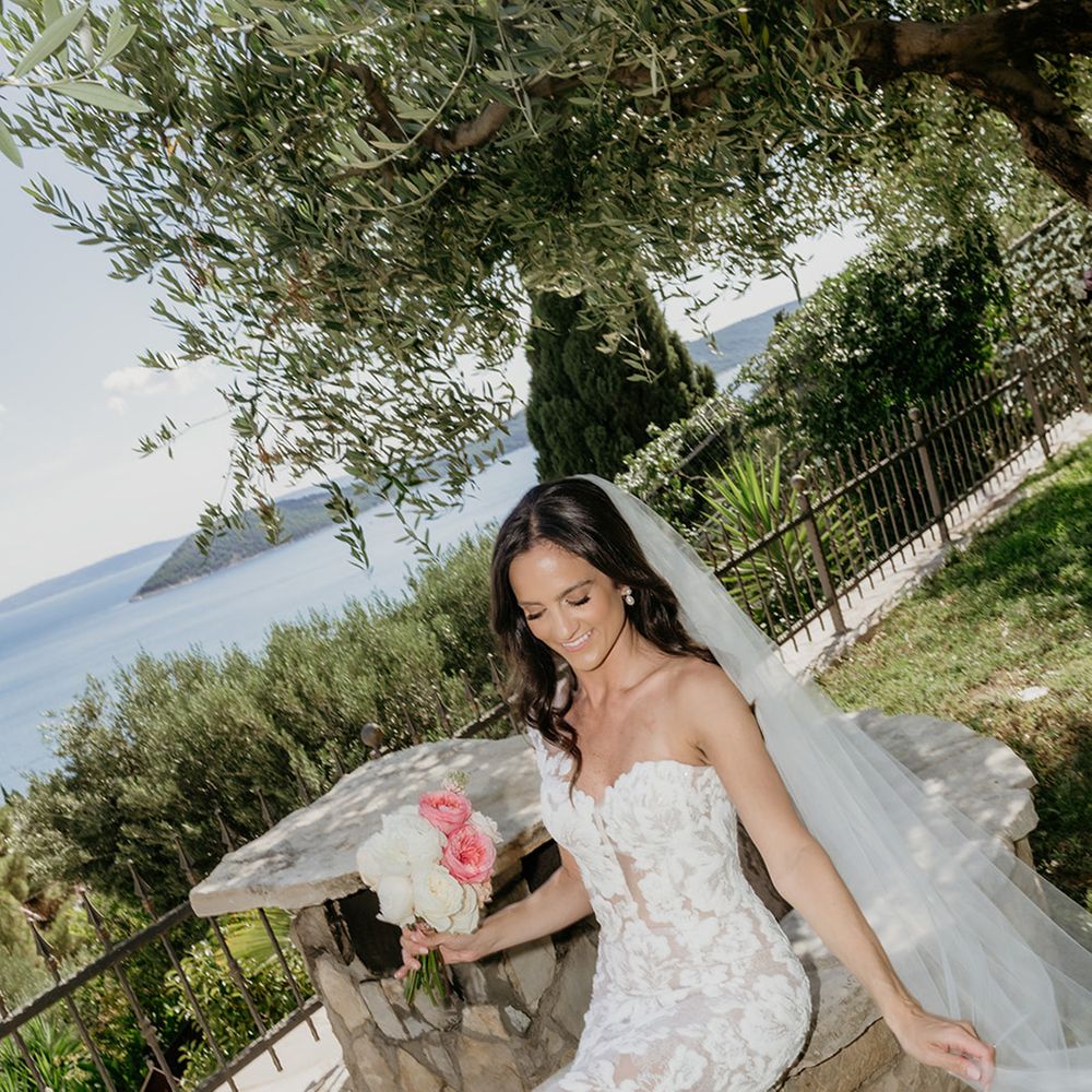 bride-in-strapless-floral-wedding-dress-with-veil-carrying-pink-and-white-bouquet