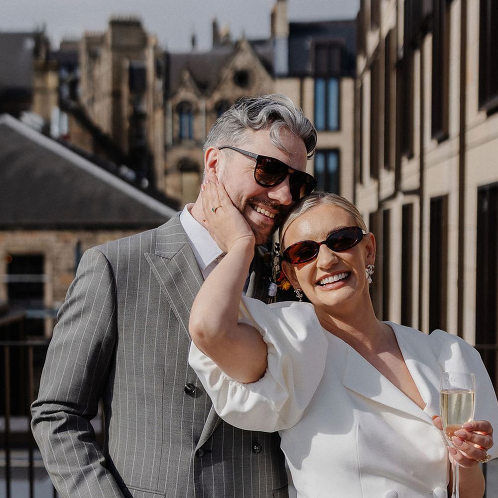 bride-in-blazer-style-wedding-dress-with-groom-in-grey-pinstrip-wedding-suit