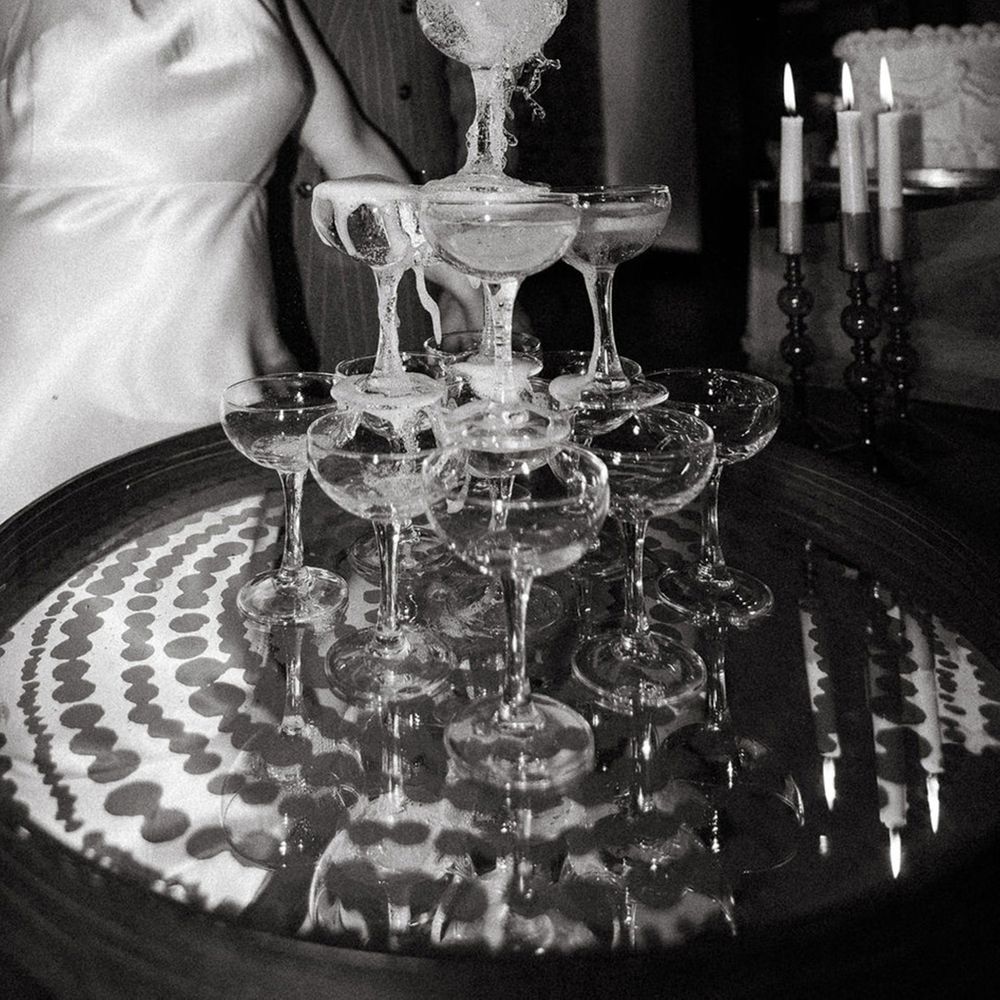 bride-in-satin-halter-neck-wedding-reception-dress-pouring-champagne-into-champagne-tower