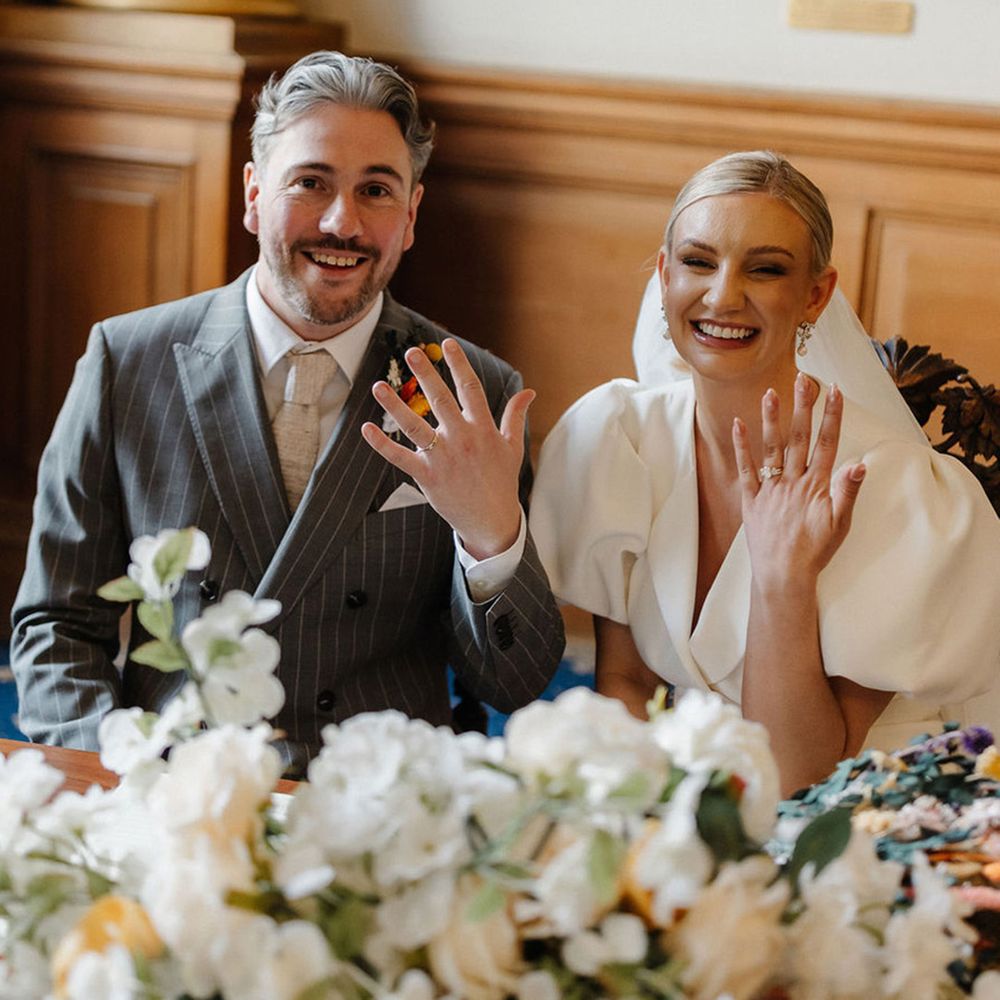 couple-show-off-their-new-wedding-rings-as-they-sign-the-register