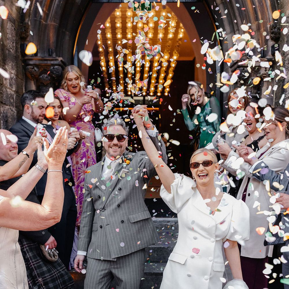 couple-wearing-sunglasses-exit-from-ceremony-as-guests-throw-confetti