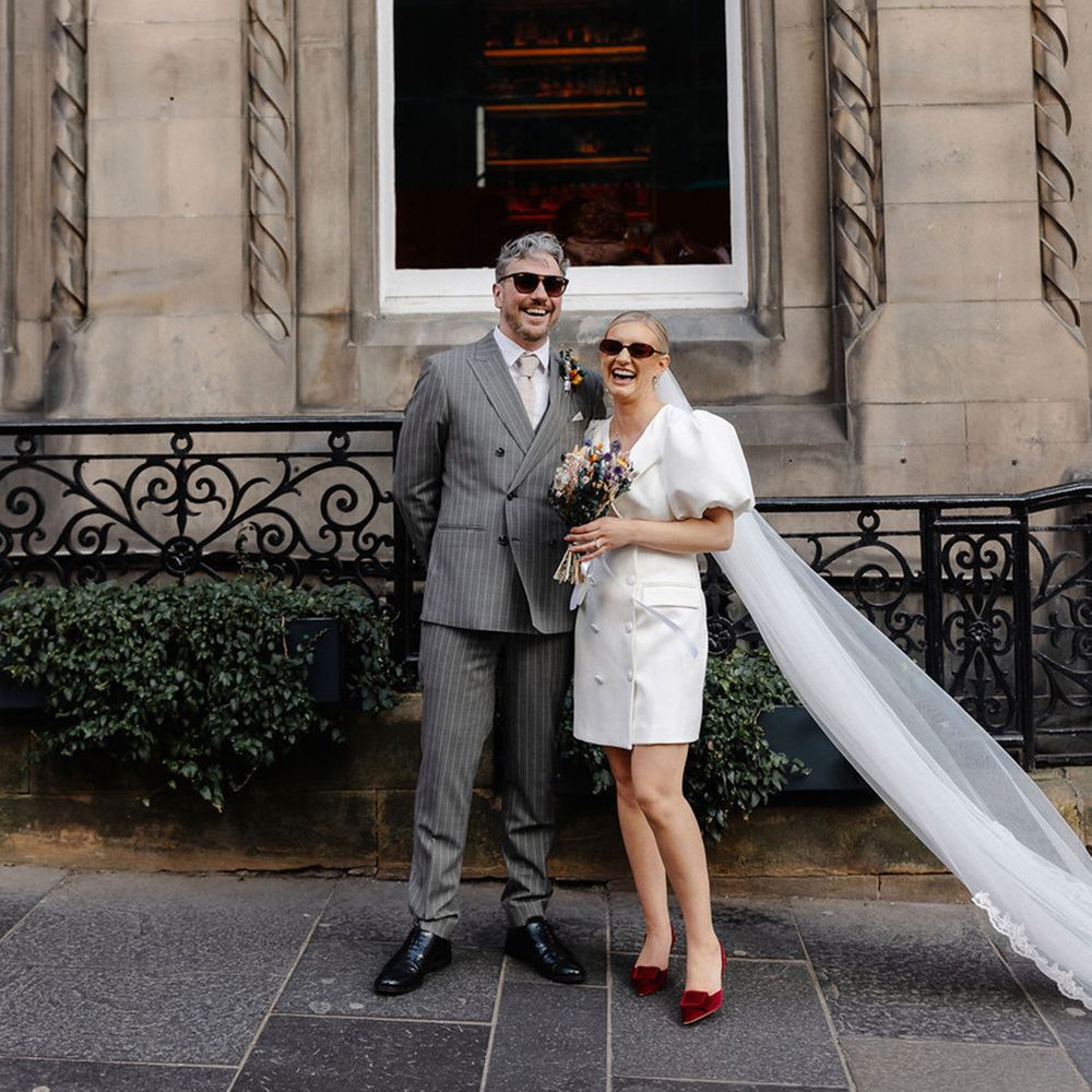 groom-in-grey-pinstripe-suit-with-bride-in-puff-sleeve-blazer-dress