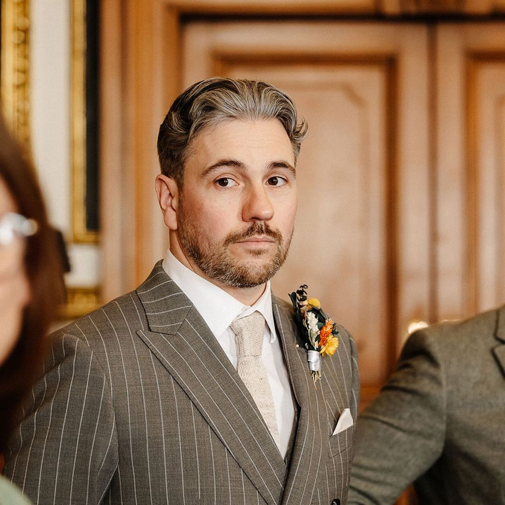 groom-wearing-grey-pinstrip-suit-with-cream-tie