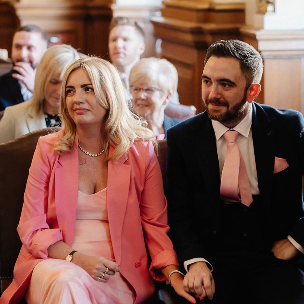 wedding-guests-wearing-pink-dress-and-tie-at-wedding-ceremony