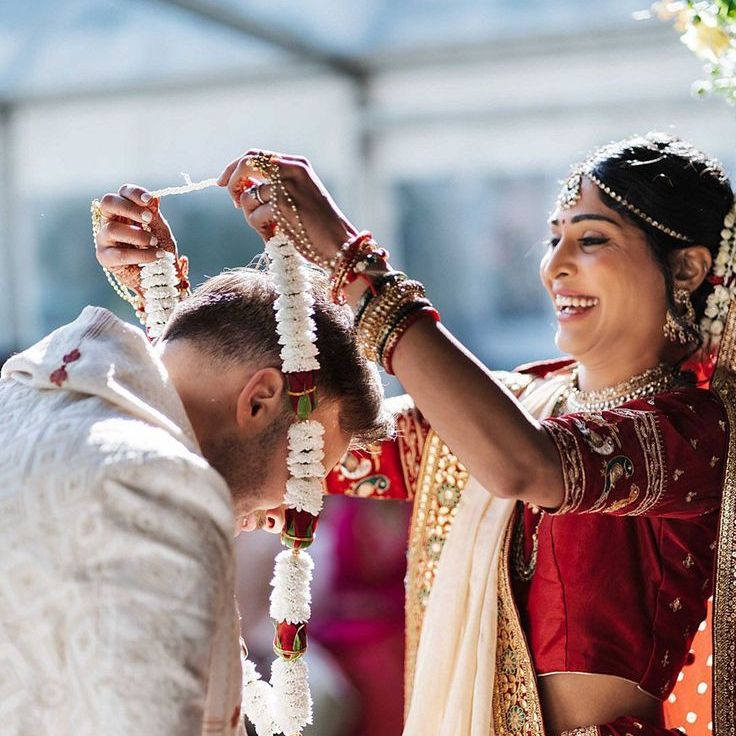 Bride in Traditional Indian Wedding Attire Places Jaimala On Groom For Multicultural Wedding