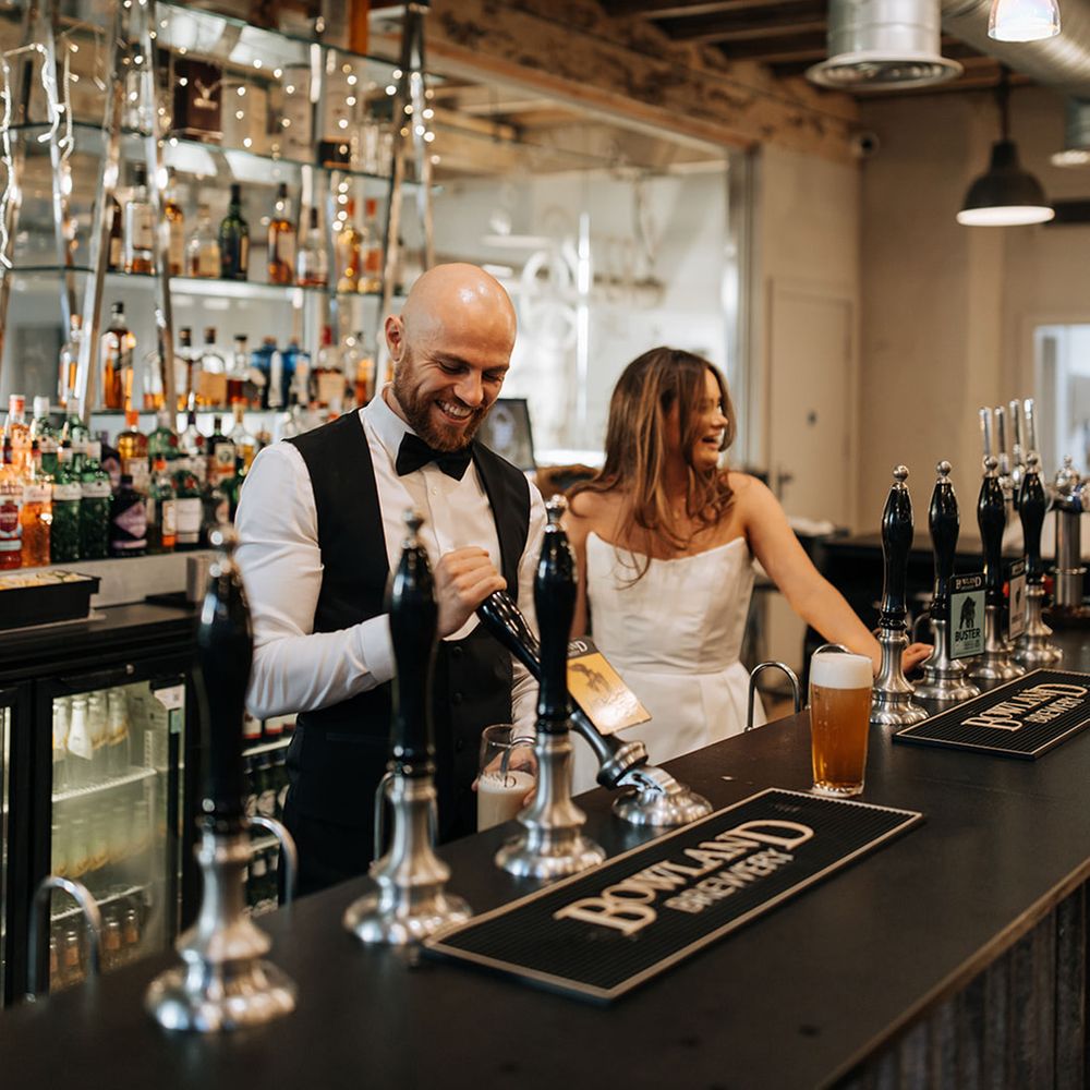 bride-and-groom-pull-pints-behind-bar