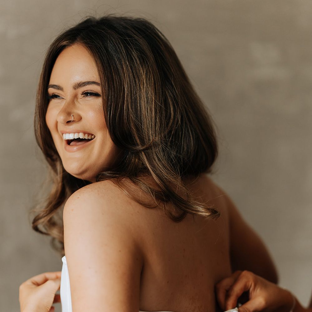 bride-gets-buttoned-up-into-strapless-fitted-wedding-dress