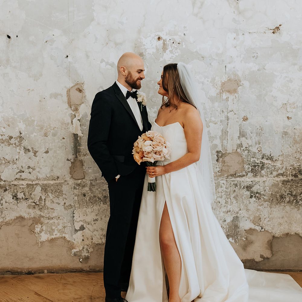 bride-in-strapless-wedding-dress-with-front-slit-with-groom-in-black-tux
