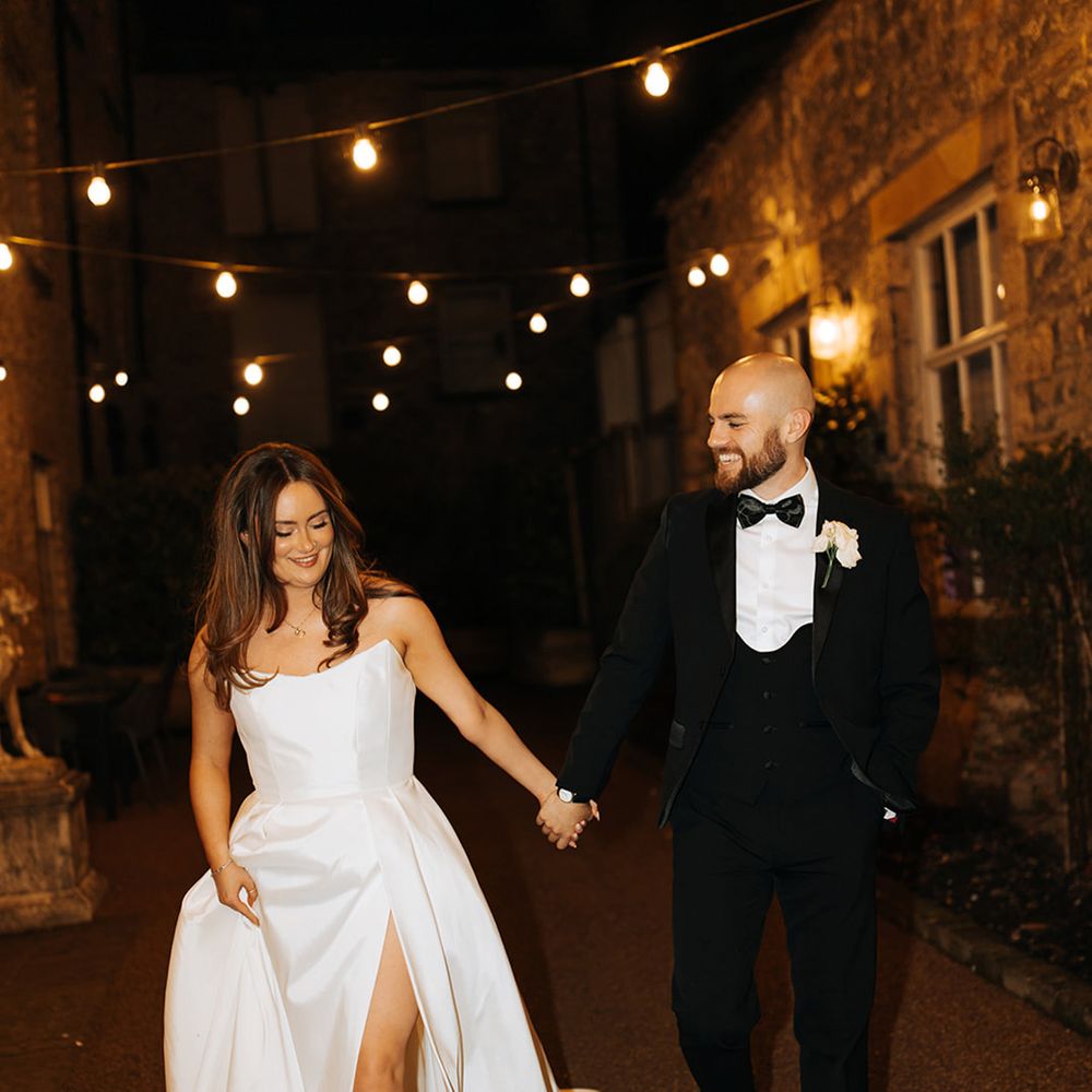 bride-in-wedding-dress--with-front-slit-walks-with-groom