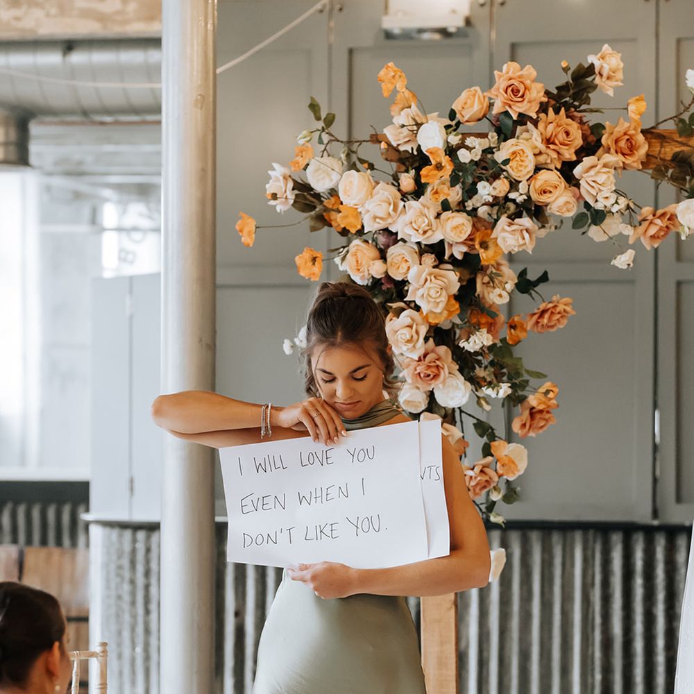 bridesmaid-holding-up-sign-with-wedding-vows