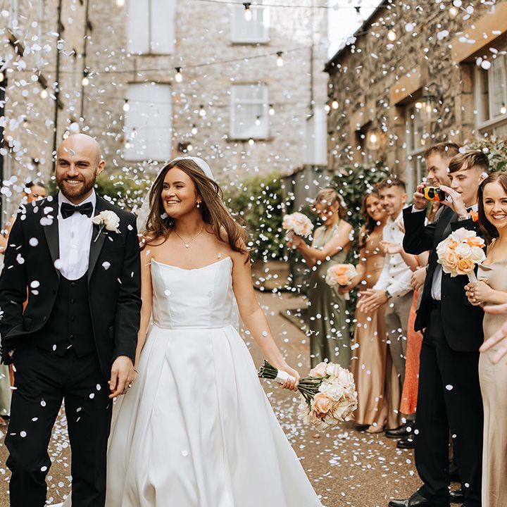 groom-in-black-tuxedo-with-bride-confetti-exit