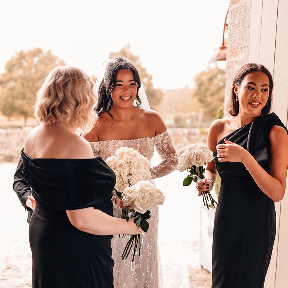 bridesmaids-in-black-dresses-with-white-floral-bouquets