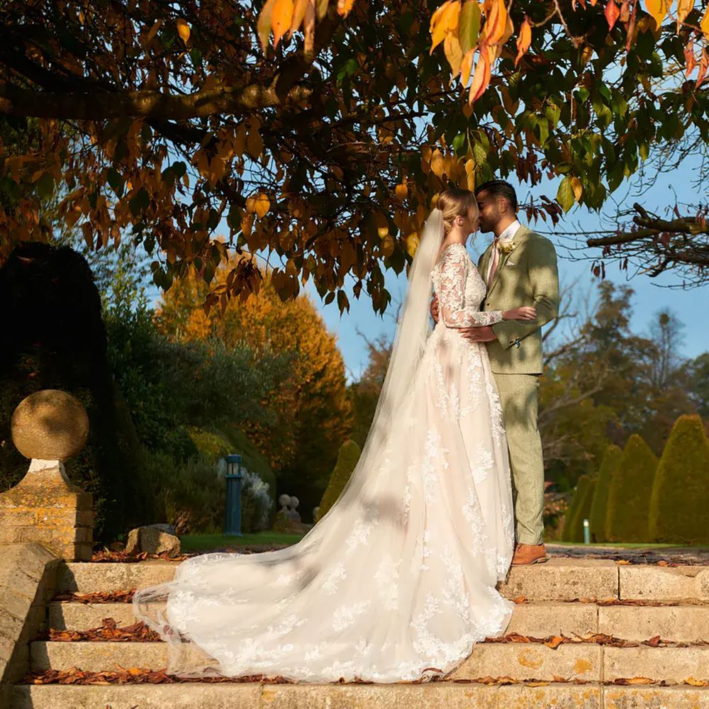 Couple kissing on steps at Hanbury Manor, sustainable wedding venue