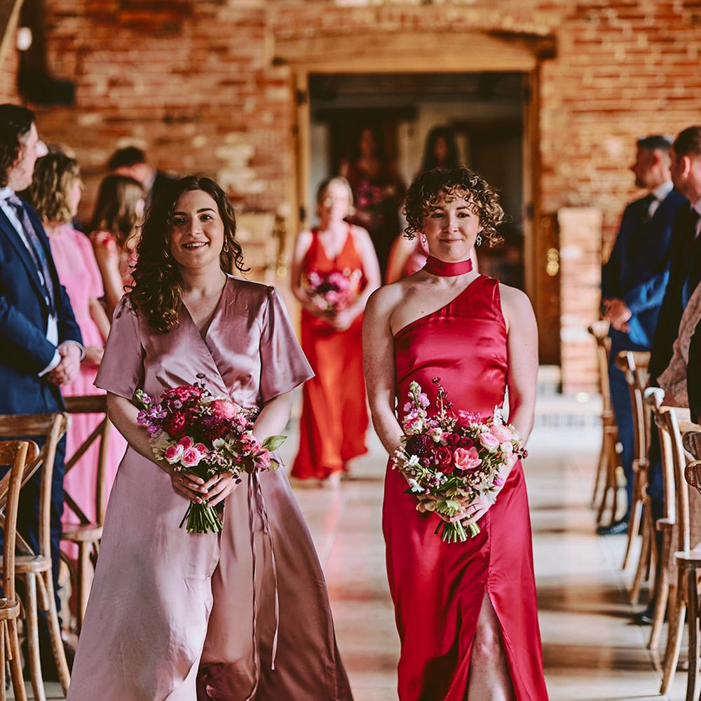 bridesmaids-in-mismatched-pink-dresses-walk-down-the-aisle