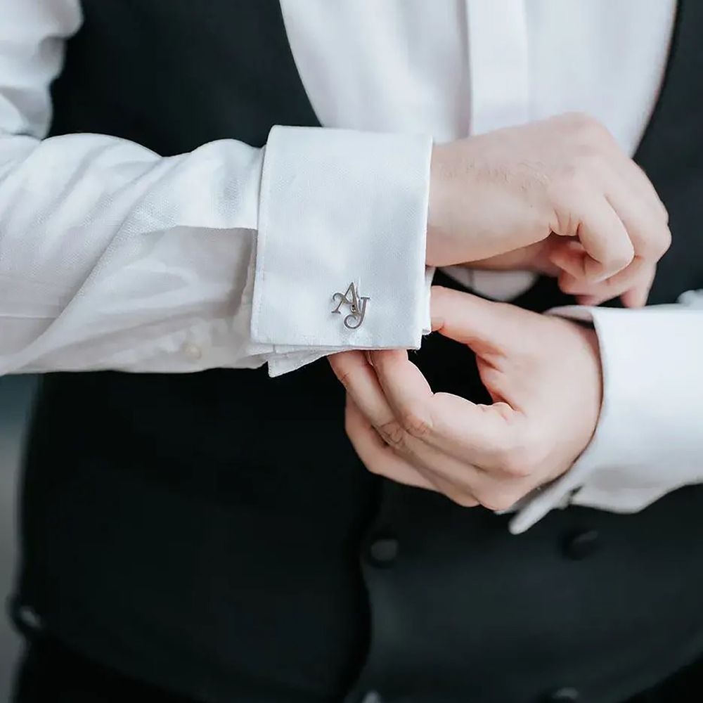 Groom putting on personalised silver initial cufflinks