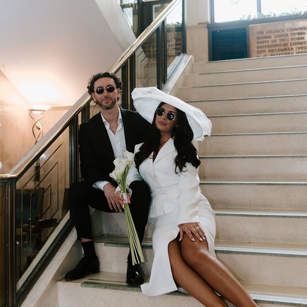 bride-and-groom-wearing-sunglasses-as-they-sit-on-steps-for-photos