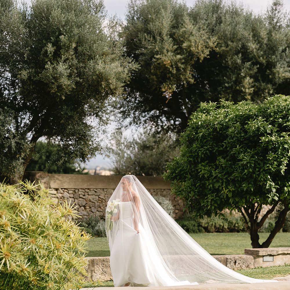 bride-walks-down-the-aisle-under-drop-wedding-veil-with-lily-bouquet