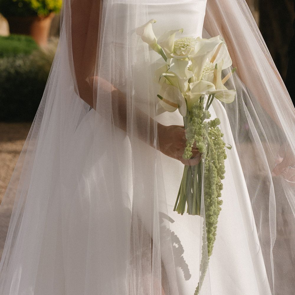 bride-wearing-wedding-veil-holding-lily-wedding-bouquet