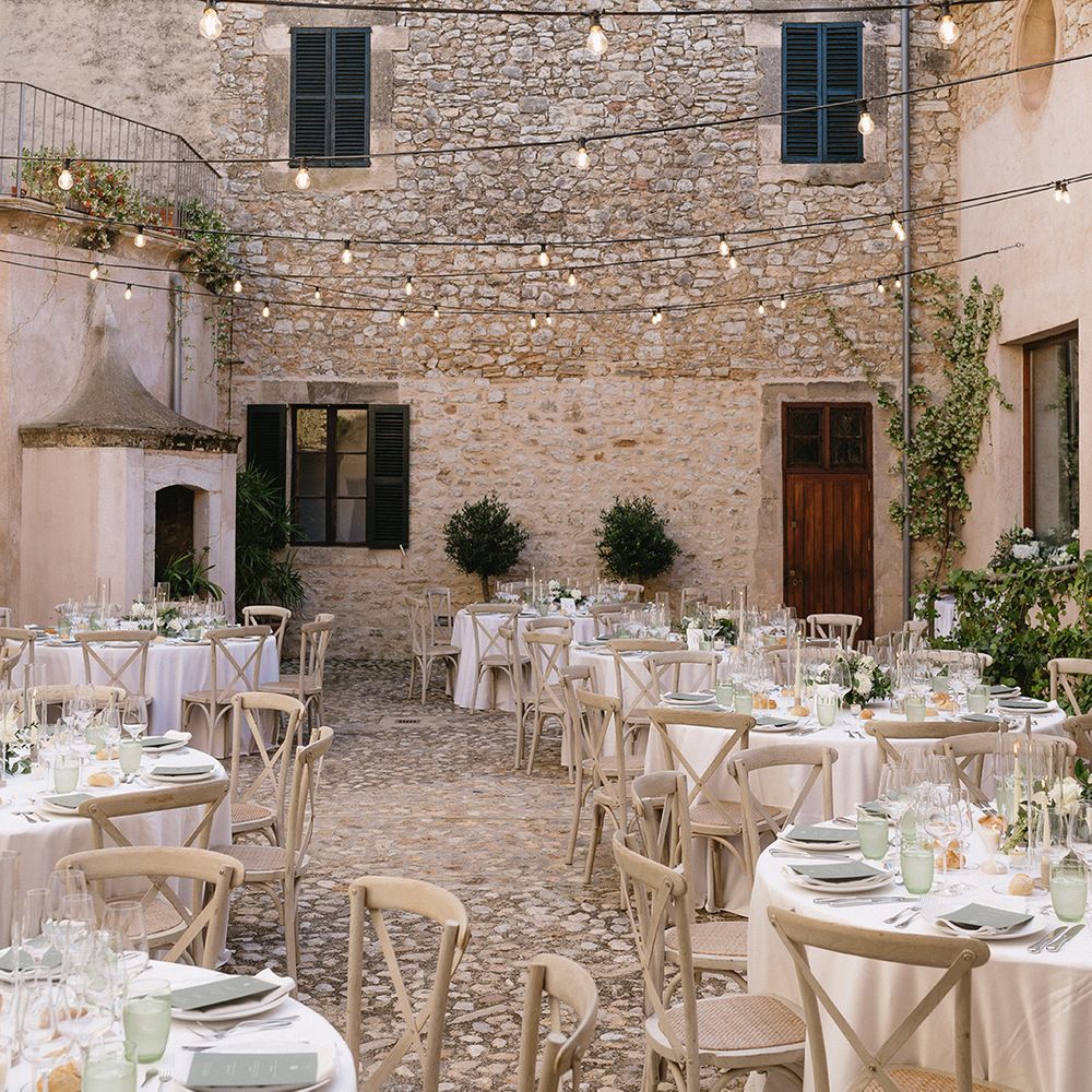 string-festoon-lights-decorate-courtyard-for-wedding-breakfast-with-green-accents