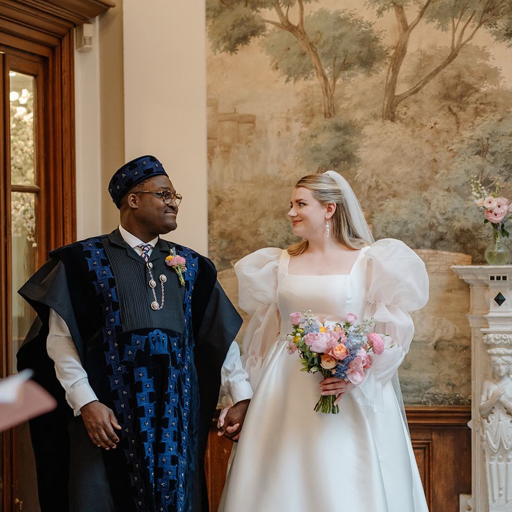 bride-in-sheer-puff-sleeve-wedding-dress-with-groom-in-dark-blue-nigerian-agbada