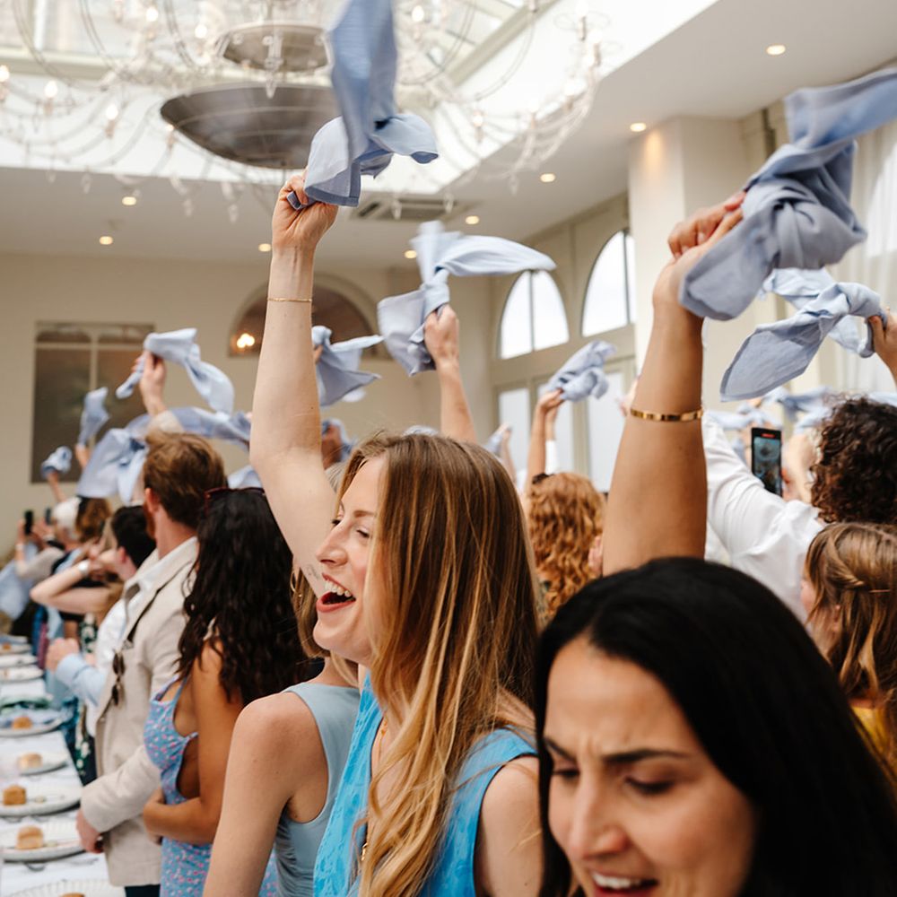 wedding-guests-waving-blue-napkins-at-wedding-breakfast