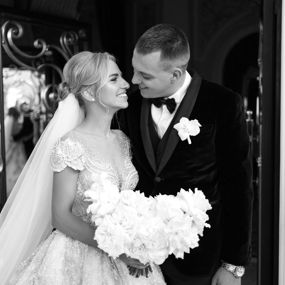 groom-in-black-tuxedo-with-bride-holding-white-bouquet