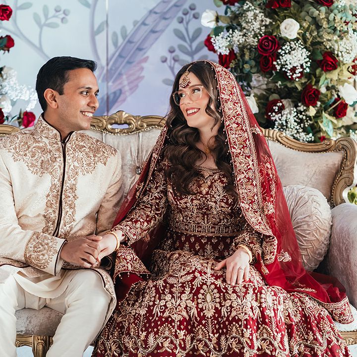 bride-in-red-and-gold-lehenga-and-groom-in-cream-sherwani
