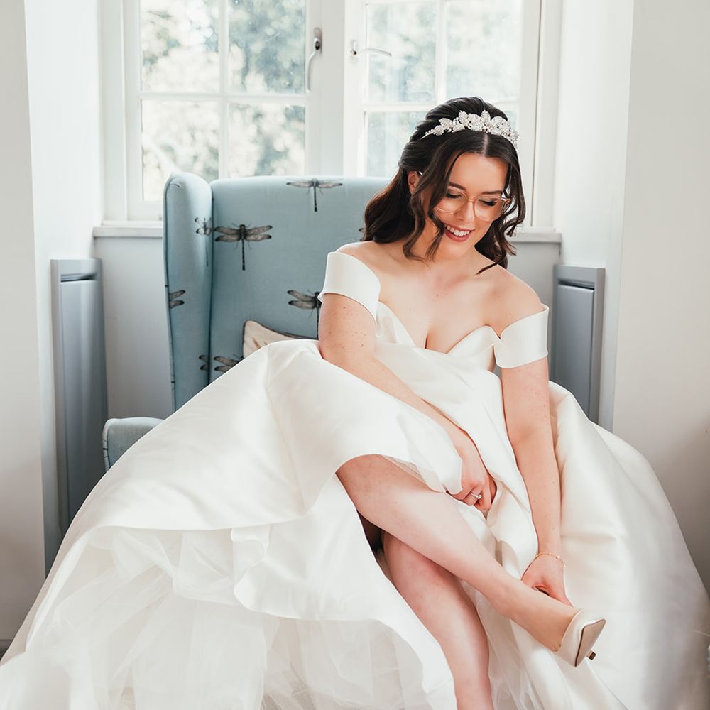 bride-puts-on-white-wedding-heels