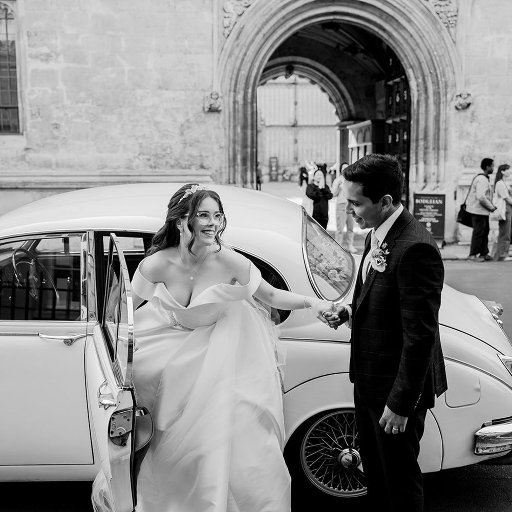 groom-helps-bride-get-out-the-white-vintage-car