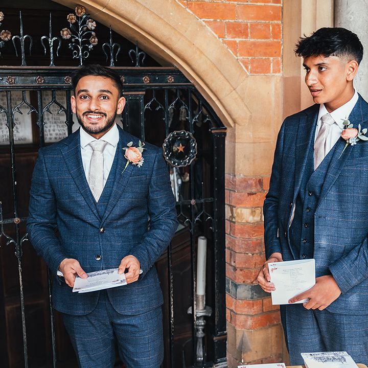 groomsmen-wearing-navy-suits-greeting-guest