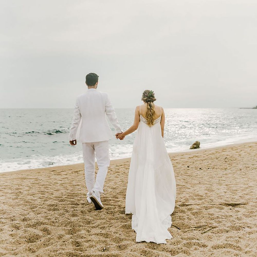 Couple holding hands on the beach for destination elopement
