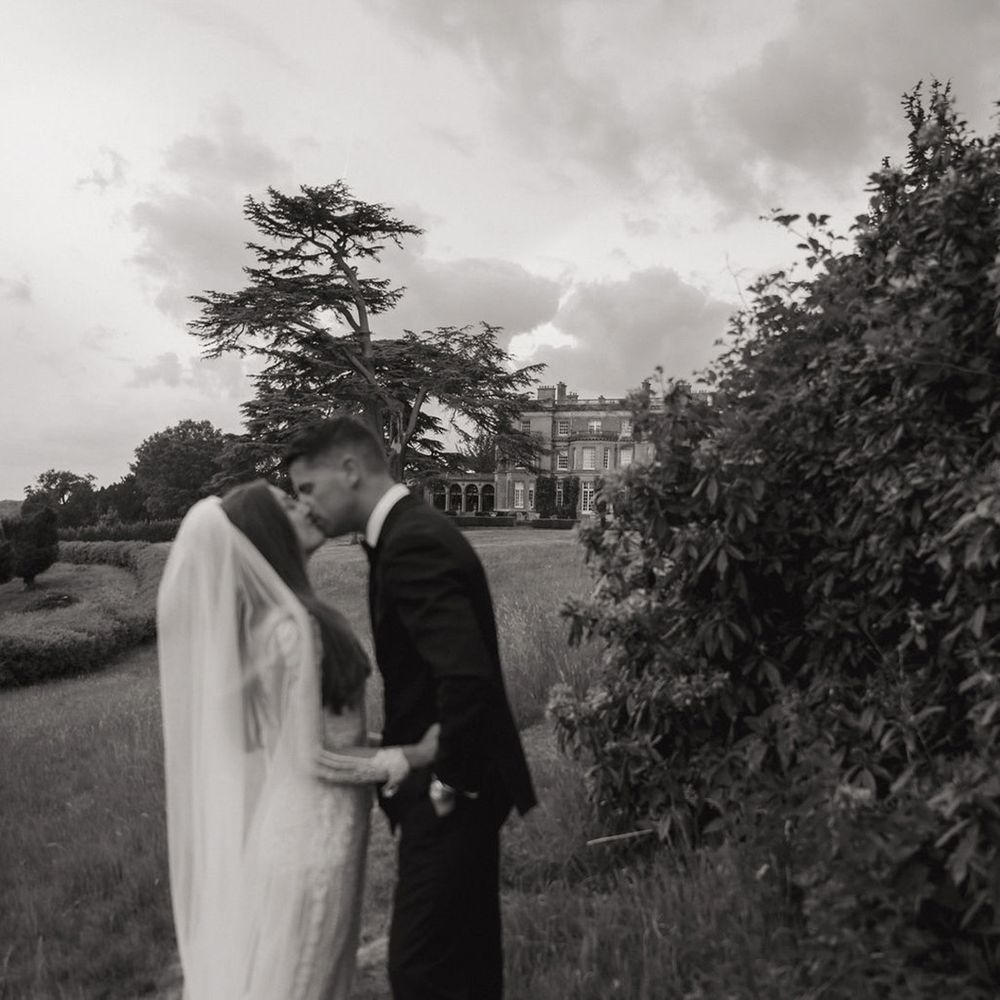 Couple shares a kiss in black and white wedding photo