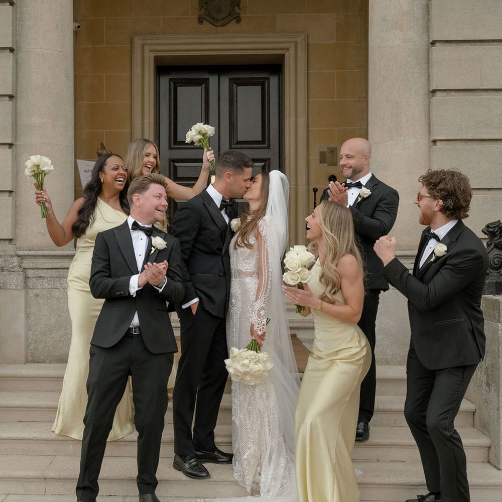 wedding-party-celebrates-as-couple-kisses