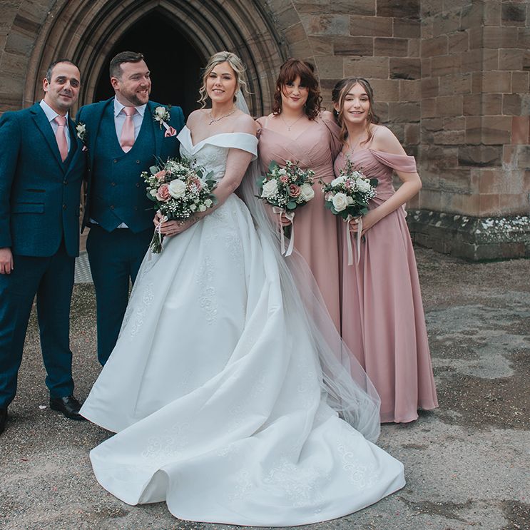 bridesmaids-in-pink-dresses-and-groomsmen-in-navy-suits-with-bride-and-groom