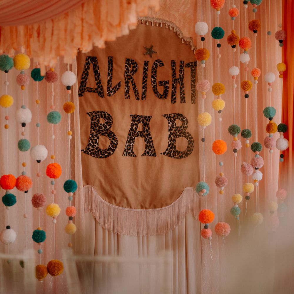 diy-wedding-sign-altar-decor-with-colourful-pom-pom-garlands