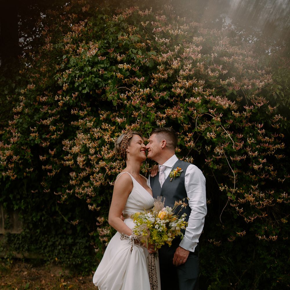 groom-leans-into-kiss-bride-wearing-leopard-print-headband