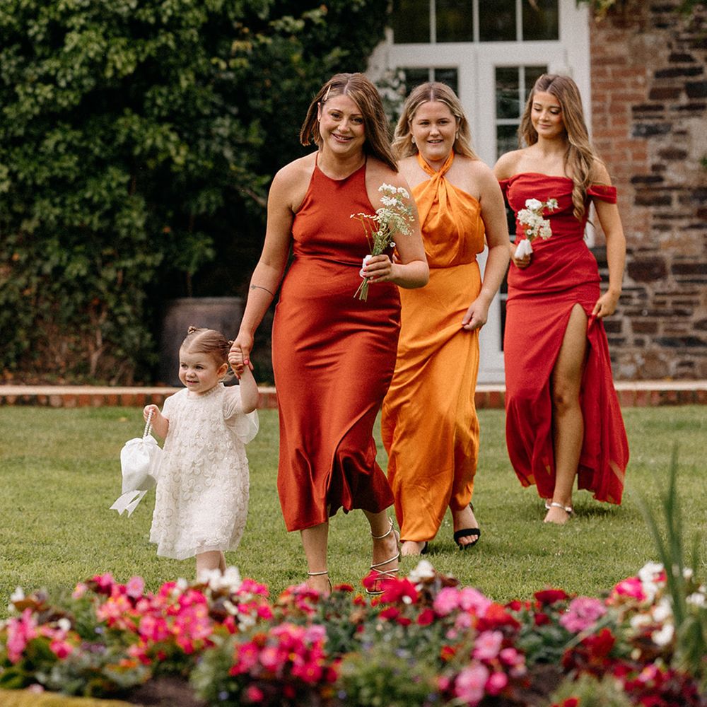 bridal-party-walks-down-the-aisle-in-burnt-orange-suits-and-dresses