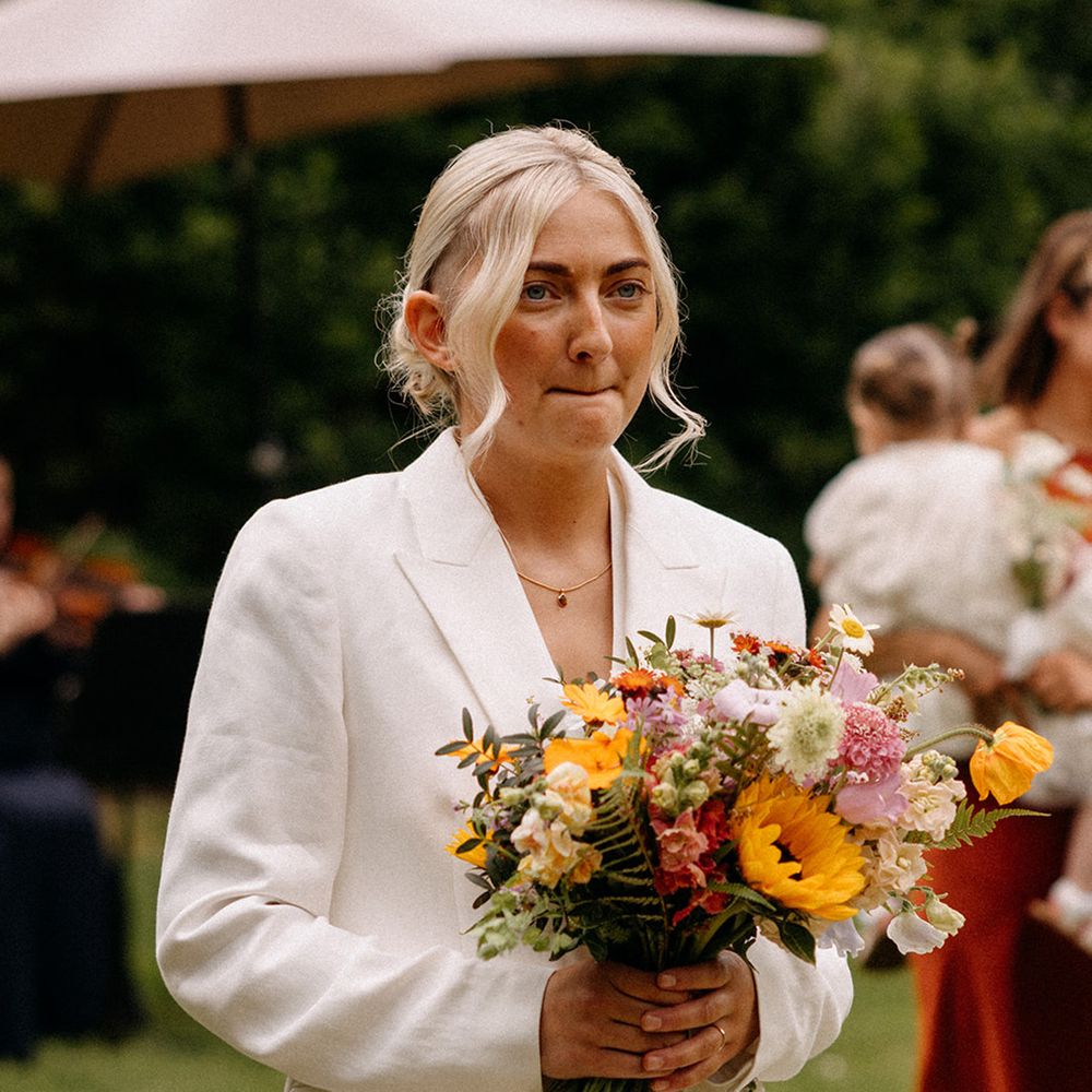 bride-in-white-wedding-suit-with-pastel-bouquet