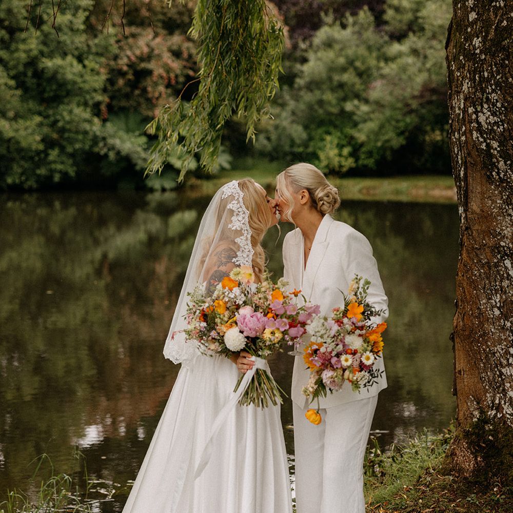brides-share-a-kiss-at-outdoor-wedding