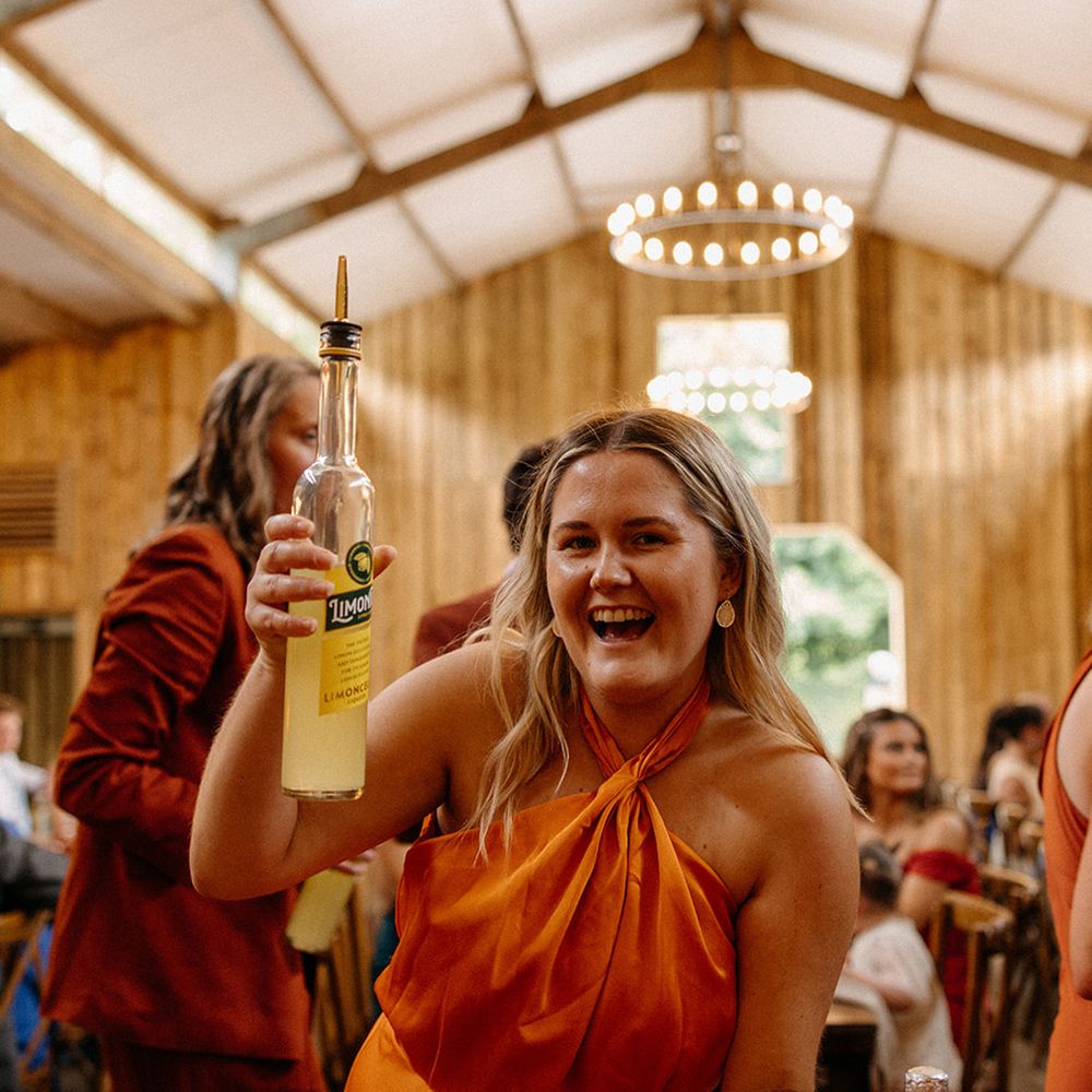 bridesmaid-in-orange-halter-neck-satin-dress-with-limoncello