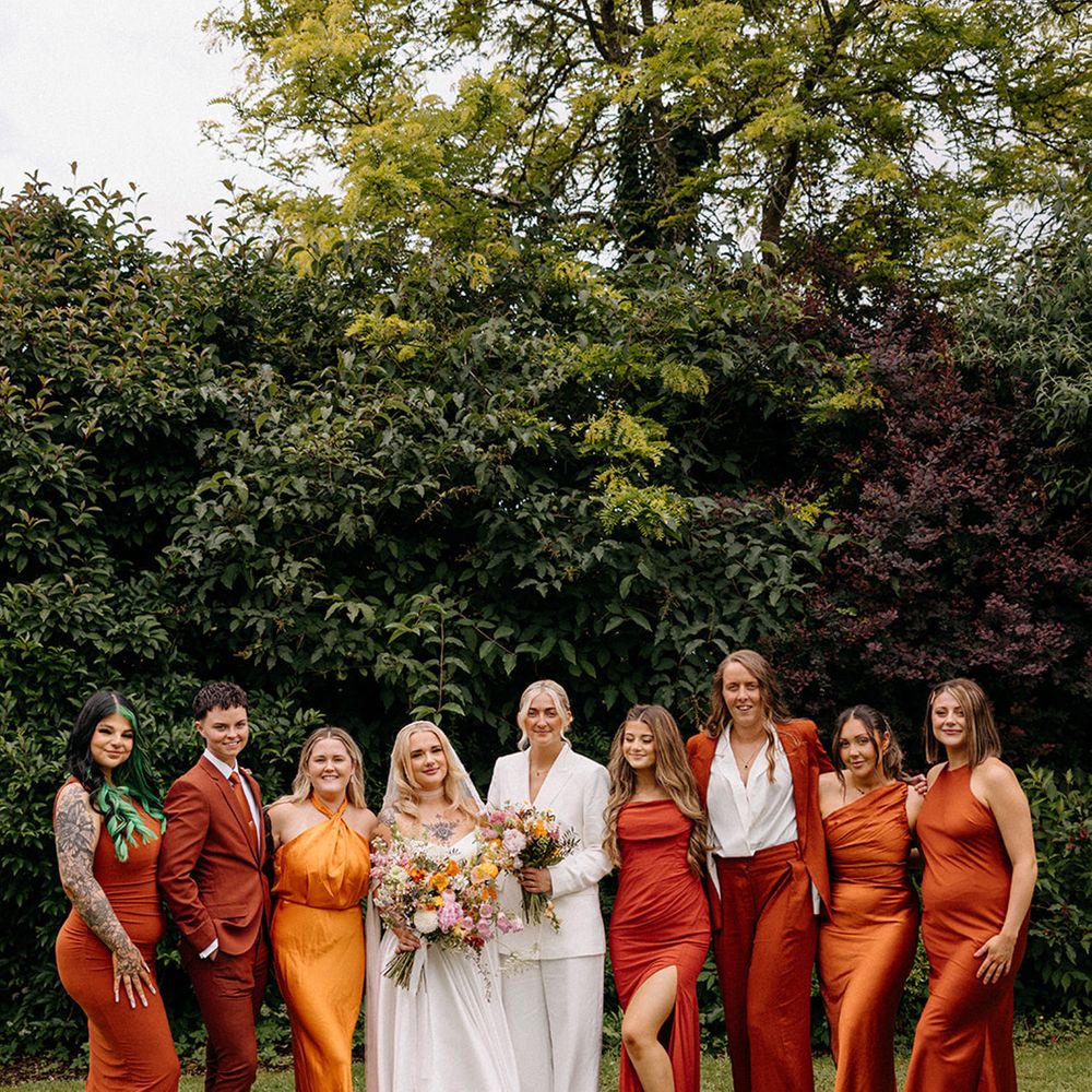 wedding-party-wearing-orange-wedding-guest-dresses-and-suits